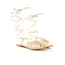 Gold sandal with straps on a white background