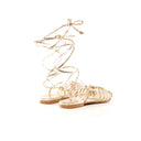 Gold strappy sandals on a white background